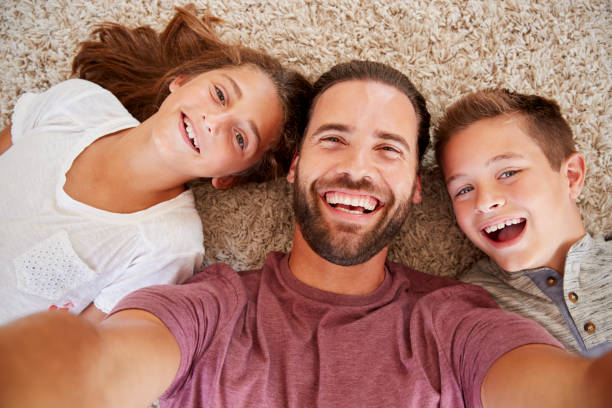 colpo di punto di vista di padre e figli in posa per selfie - famiglia con due figli foto e immagini stock