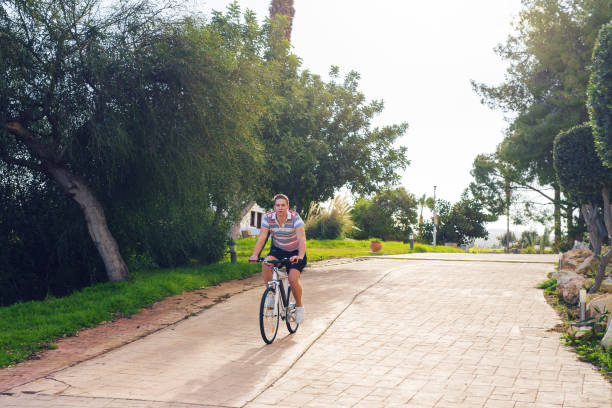 istock a young man riding a bicycle in a park 976810750
