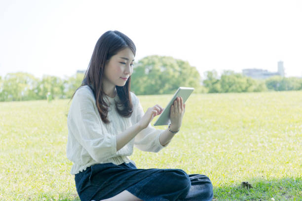 istock A woman who operates a tablet on the lawn 976811906