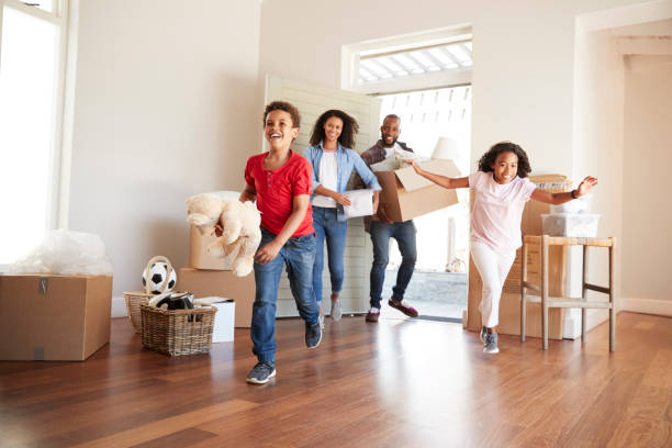 excited family carrying boxes into new home on moving day - family white family with two children cheerful imagens e fotografias de stock