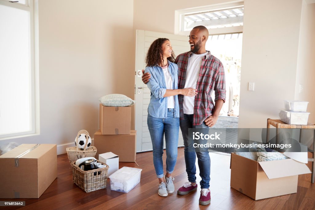 Couple heureux entouré de boîtes dans la nouvelle maison le jour du déménagement - Photo de Propriétaire immobilier libre de droits