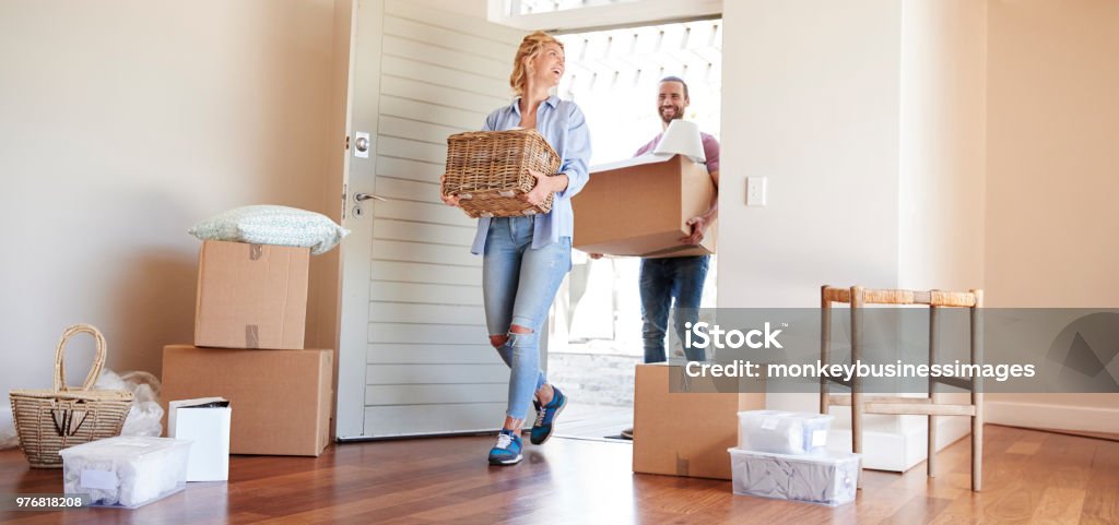 Couple transportant des boîtes dans la nouvelle maison pour bouger jour - Photo de Propriétaire immobilier libre de droits