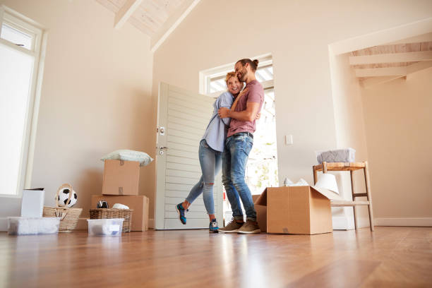 istock Happy Couple Surrounded By Boxes In New Home On Moving Day 976820376