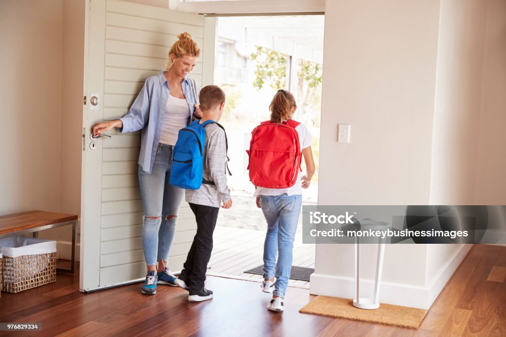 Mother Getting Children Ready To Leave House For School Leaving Stock Photo