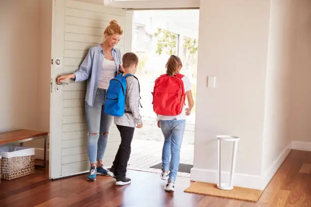 Photo of Mother Getting Children Ready To Leave House For School