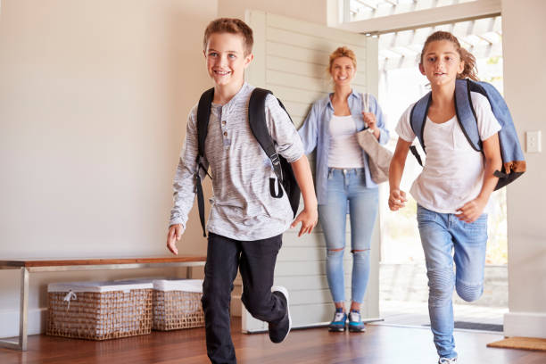 istock Mother And Children Returning Home After School Day 976829430