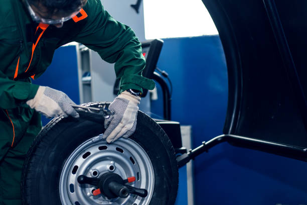 Mechanic man working on balancing machine Mechanic man working on balancing machine car transporter stock pictures, royalty-free photos & images