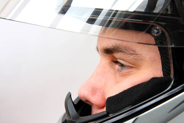 Smiling man in motorcycle helmet with speakerphone. Communication while riding a motorcycle concept