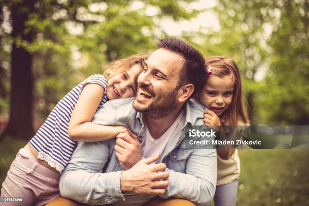 Padre con hijas en el parque. - Foto de stock de Padre libre de derechos