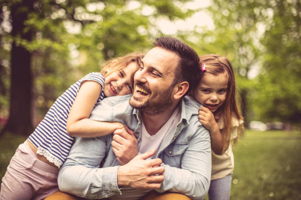 padre con figlie al parco. - famiglia con due figli foto e immagini stock