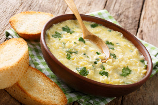 istock Children's egg cream soup stracciatella with farfalline and cheese close-up in a plate. horizontal 976900082
