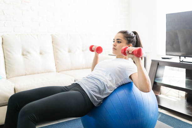 istock Woman doing dumbbell workout on swiss ball 976900428