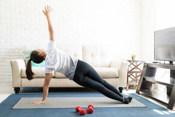 istock Woman practicing side plank yoga at home 976907430