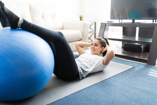 istock Woman doing abs workout with swiss ball 976908798
