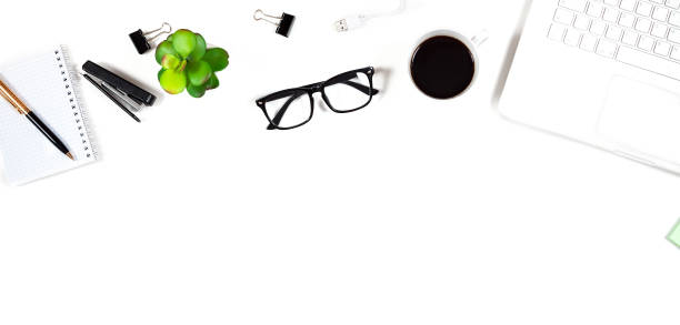 istock Office table with a computer, a notebook, glasses, a stapler and a cup of coffee 976912484