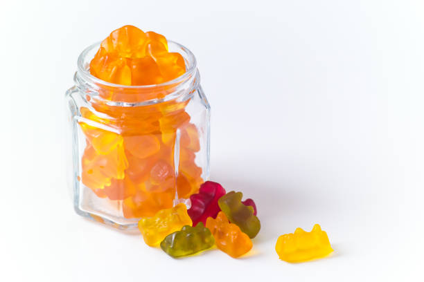 Orange jelly bears in a bottle, few of mixed colors outside