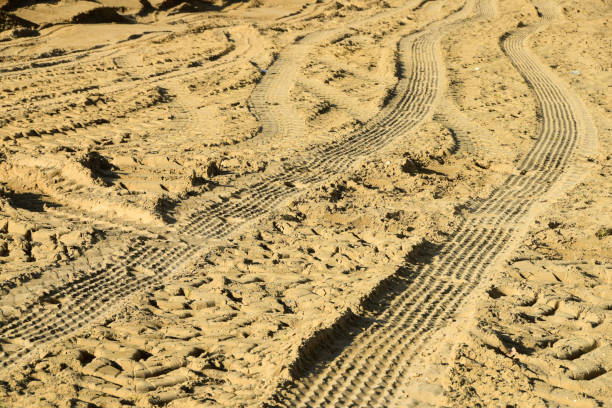 istock Tire tracks on the sand as a background 976913326