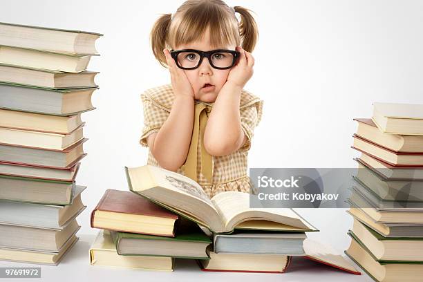 Worried Little Girl Wearing Glasses Surrounded By Books Stock Photo - Download Image Now