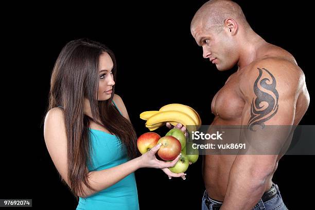Photo libre de droit de Attrayant Couple Musculaires Avec Des Fruits banque d'images et plus d'images libres de droit de Adulte - Adulte, Aliment, Banane - Fruit exotique