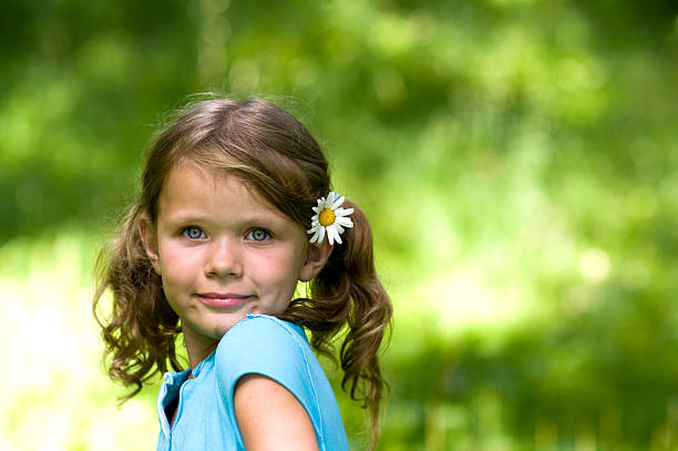 Cute Little Girl with a Flower in her hair stock photo