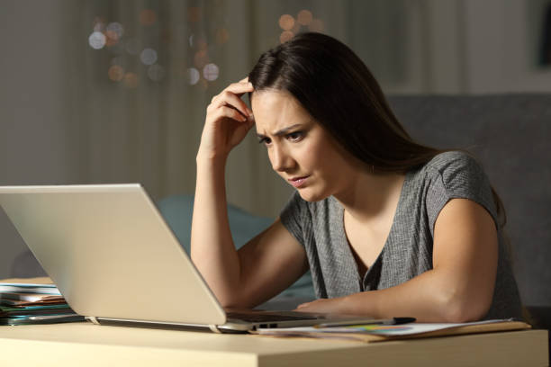 istock Confused woman working online late hours 976957748