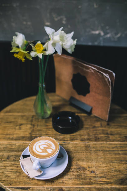 istock Cup of flower latte art on a coffee table 976957752