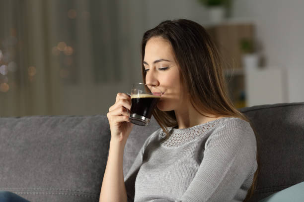 Lady drinking coffee at home in the night