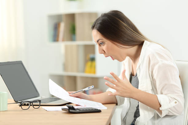 istock Surprised woman reading bank statement 976960424