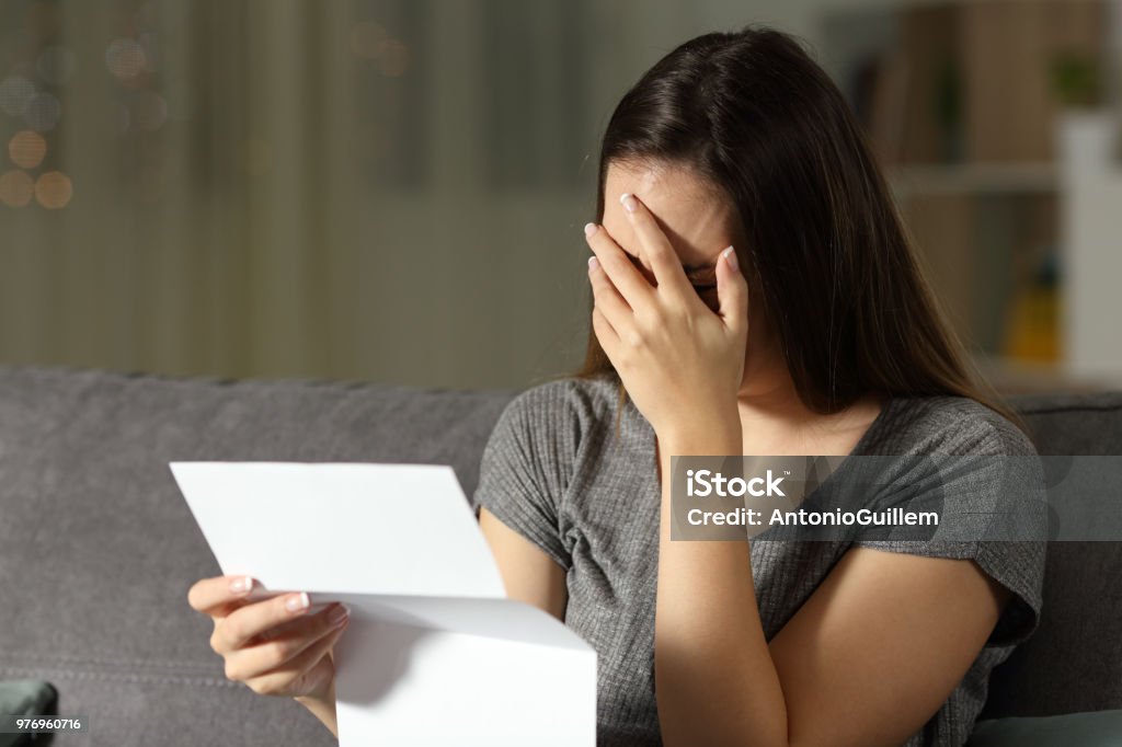 Mulher triste lendo uma carta no escuro - Foto de stock de Carta - Documento royalty-free