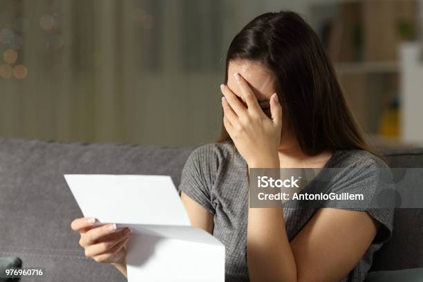 Foto de Mulher Triste Lendo Uma Carta No Escuro e mais fotos de stock de Carta - Documento - Carta - Documento, Inquilino, Mulheres