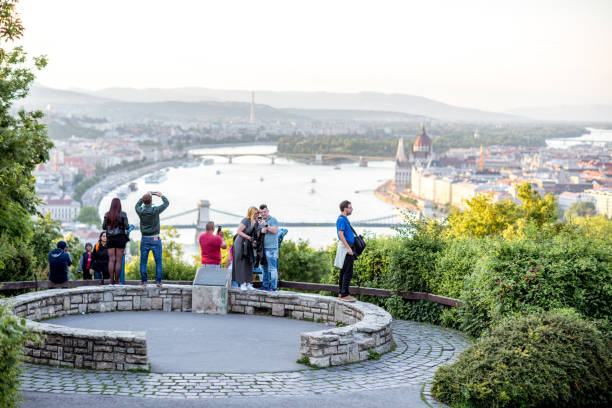 HUNGARY, BUDAPEST - MAY 20, 2018: Tourists enjoying great view on Budapest city standing on the Gellert hill viewpoint during the sunset