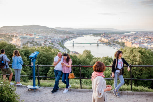 HUNGARY, BUDAPEST - MAY 20, 2018: Tourists enjoying great view on Budapest city standing on the Gellert hill viewpoint during the sunset