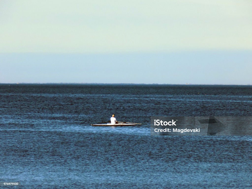 Lonely man in the rowboat in the middle of the sea Midsection Stock Photo