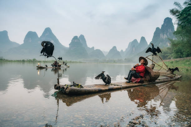 istock chinese fisherman taking a break on bamboo raft 976979258