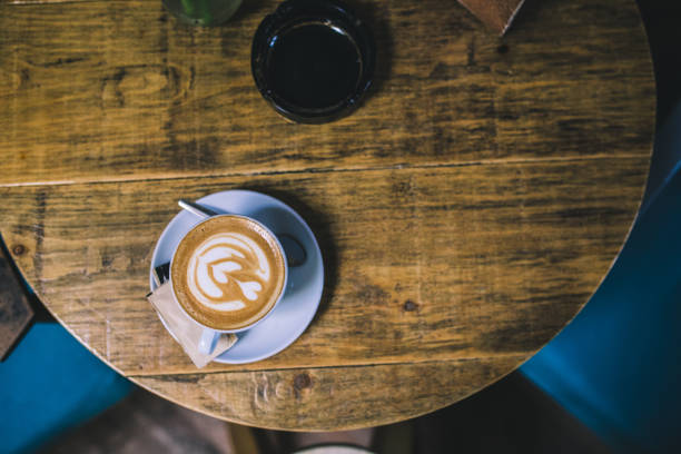 istock Cup of flower latte art on a coffee table 976996966