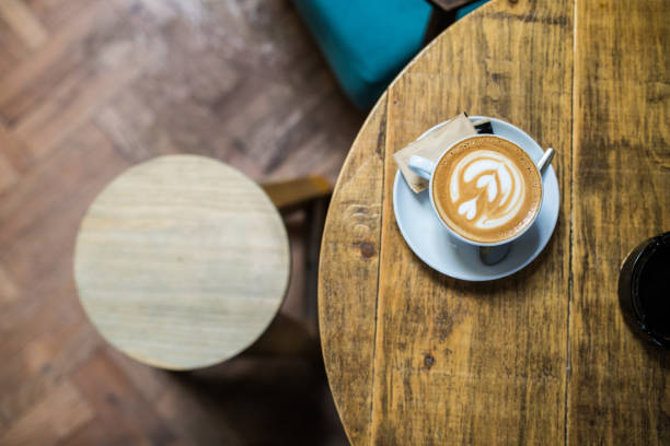 istock Cup of flower latte art on a coffee table 977000202