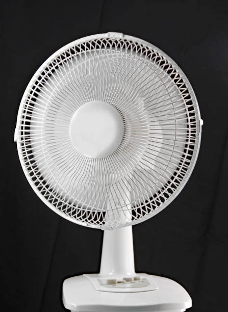 istock Small home floor fan on a black background 977011570