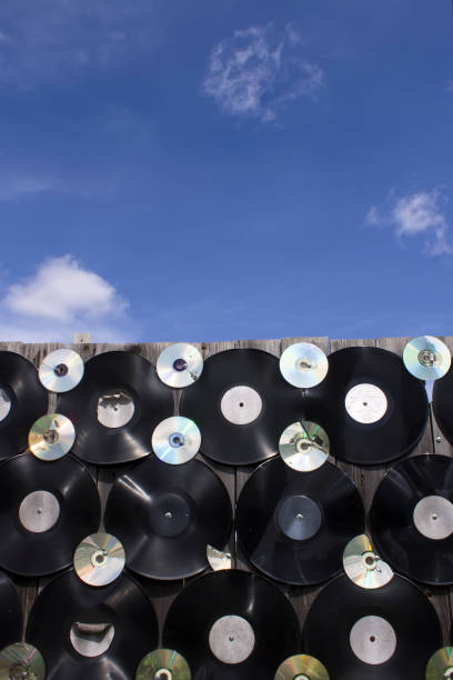 vinyles et cd sont vissés à une clôture sur un fond de nuages - breaking wind audio photos et images de collection