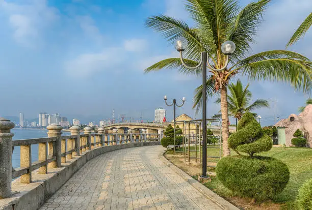 Vietnam, Nha Trang. 2 May 2015. The embankment with the topiary bushes in the shape of a spiral. Bridge over the river  Kai.