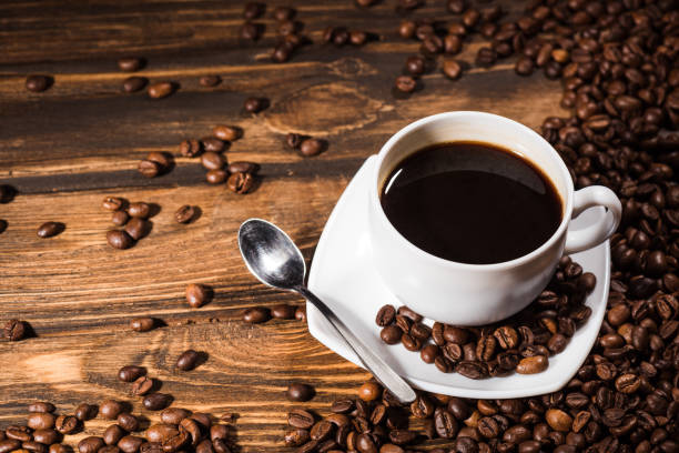 istock high angle view of coffee cup on rustic wooden table spilled with beans 977065342
