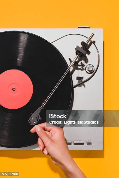 Cropped Shot Of Woman Turning On Vinyl Player Isolated On Yellow Stock Photo - Download Image Now