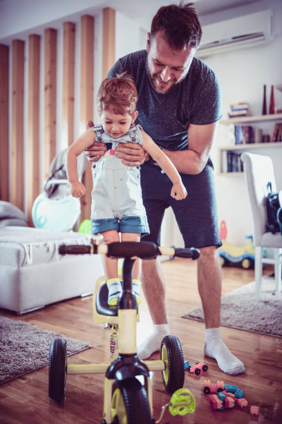 istock Father Introducing Baby Son To His New Tricycle 977103744