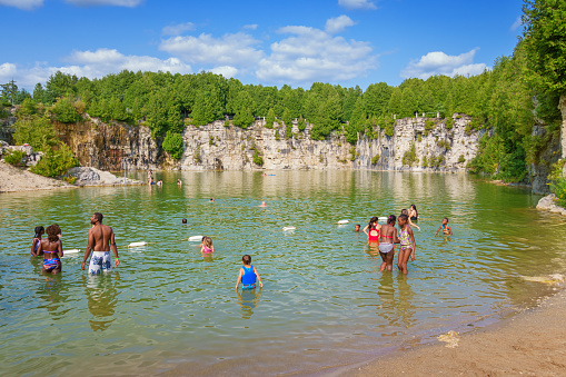 People relax in the water at Elora Quarry Conservation Area near Guelph Ontario Canada on a sunny day