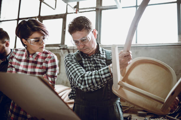 istock Team Of Carpenters Examining Work Results And Comparing Blueprints 977113516