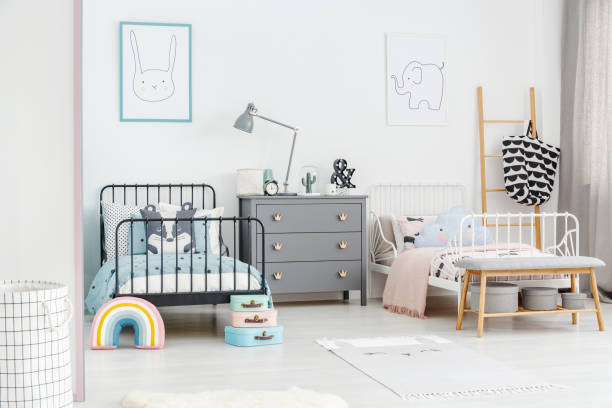 istock Lamp on grey cabinet between black and white bed in siblings bedroom interior with posters. Real photo 977160656