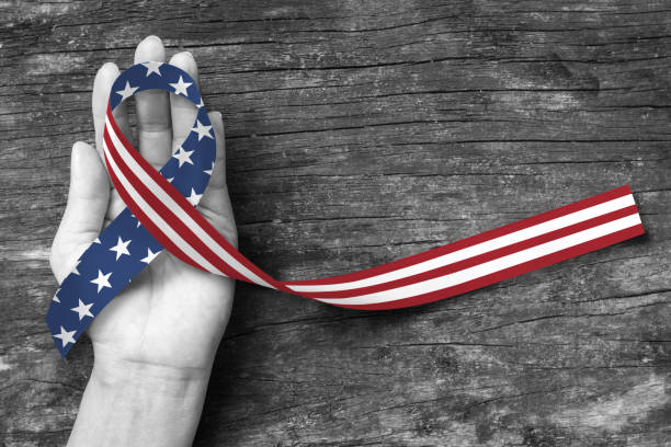 istock American flag pattern awareness ribbon color splashed on human hand grunge background: United states of america public holiday USA national day, nationalism raising US nation support campaign concept 977164734