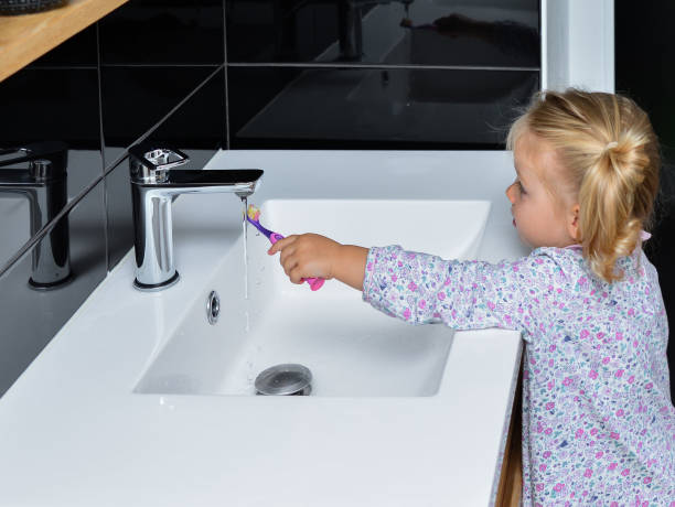 istock Little girl brushing teeth in the bath 977165006