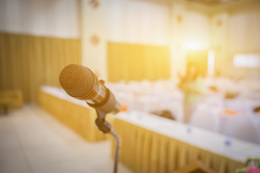 Close up of microphone in concert hall or conference seminar room background,selective focus,vintage color,copy space