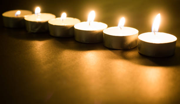istock Many burning candles with shallow depth of field on black background 977259814