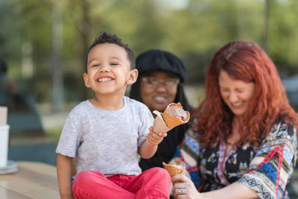 istock Two moms eat ice cream with their three-year old son 977263514